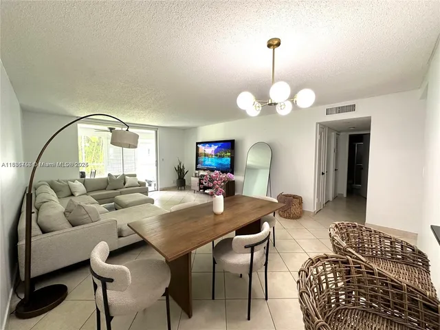 a living room with furniture a mirror and a chandelier