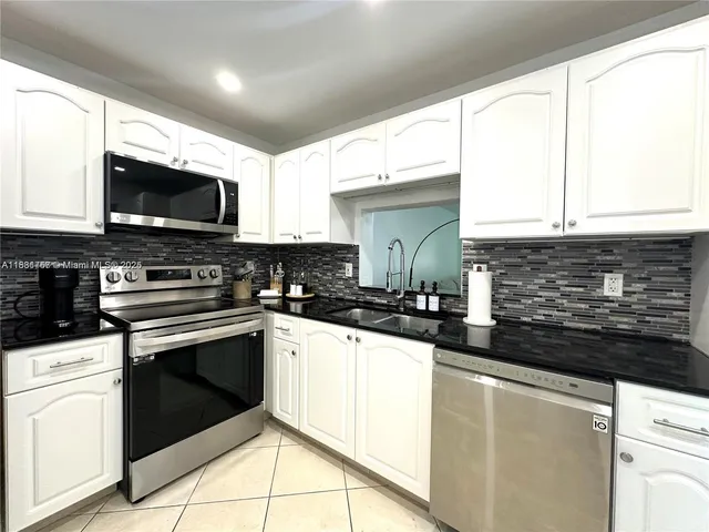 a kitchen with stainless steel appliances granite countertop a stove sink microwave and cabinets