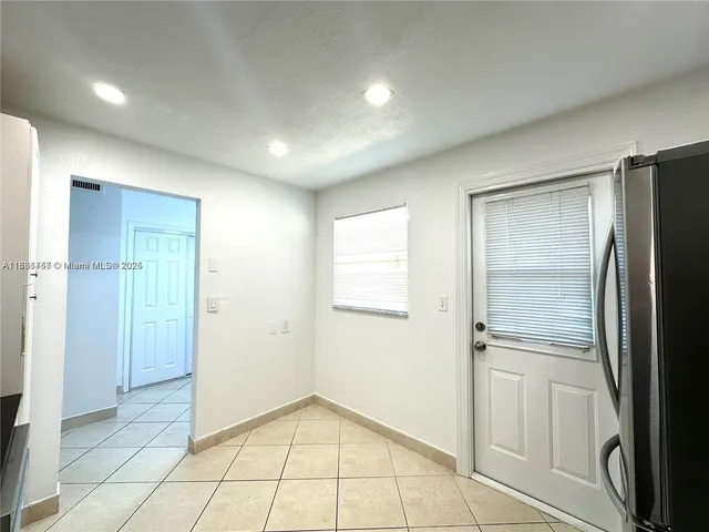 a view of an empty room with a kitchen