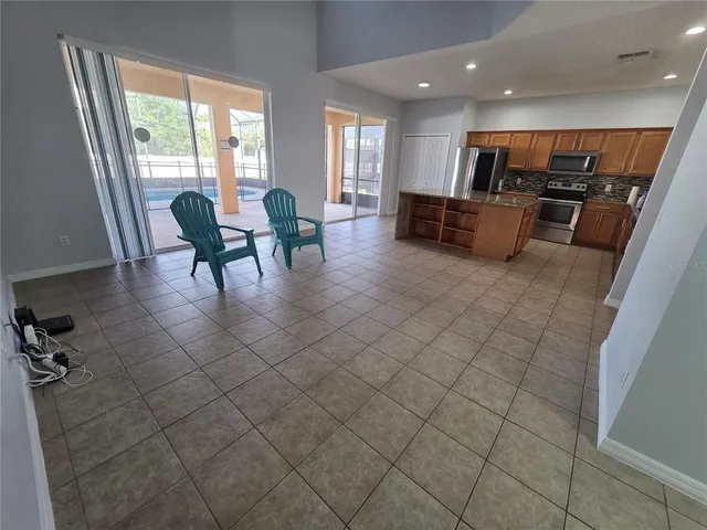 a living room with furniture kitchen and a large window