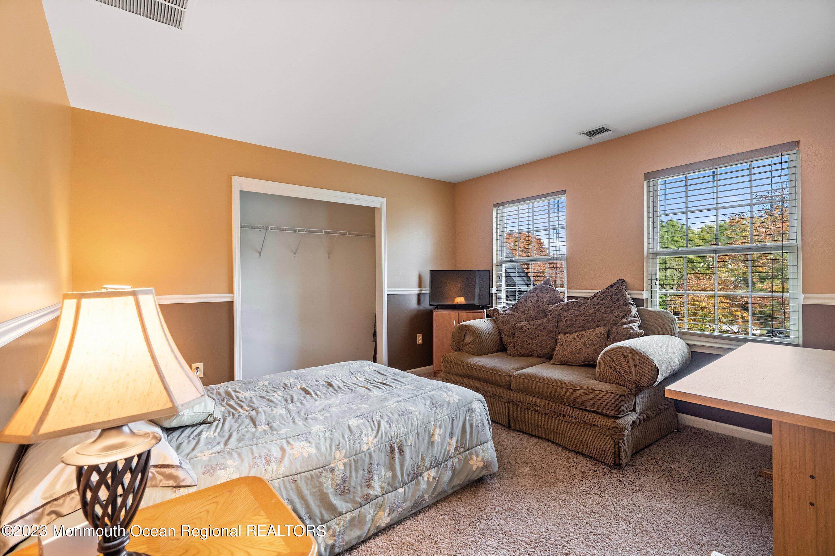 30 Cedar Knoll Road Jackson, NJ 08527 - Photo 21 of 24 a large bedroom with a bed and a couch next to a window