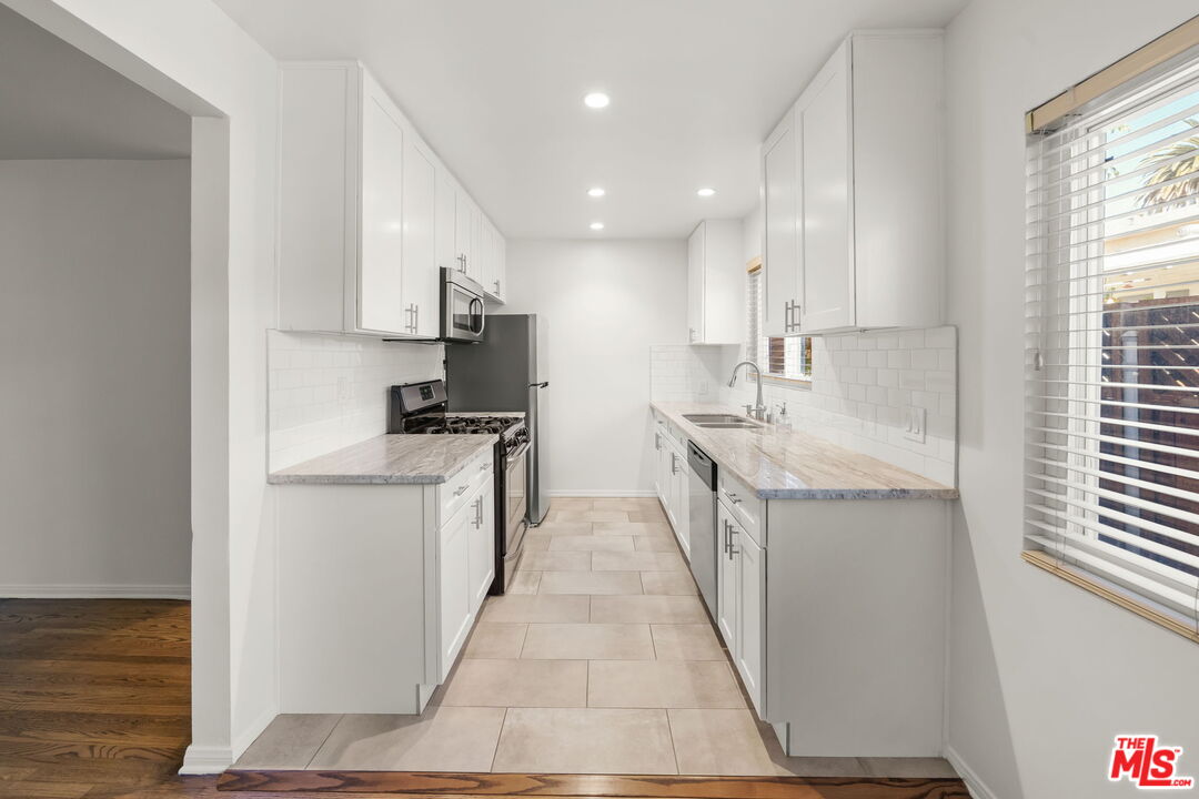1517 Harvard Street, Unit 3 Santa Monica, CA 90404 - Photo 11 of 20 a kitchen with stainless steel appliances granite countertop a sink and cabinets