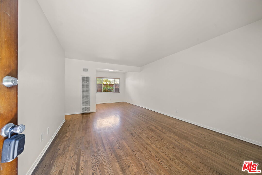1517 Harvard Street, Unit 3 Santa Monica, CA 90404 - Photo 4 of 20 a view of an empty room with wooden floor and a window