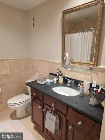 a bathroom with a granite countertop sink a toilet and a mirror