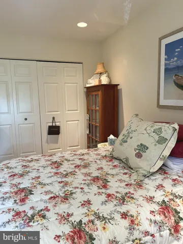 a large bedroom with a bed and wooden floor