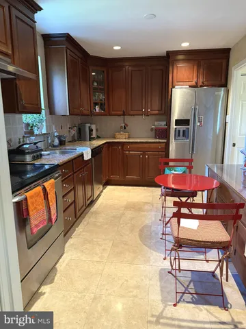 a kitchen with stainless steel appliances granite countertop a refrigerator and a stove top oven