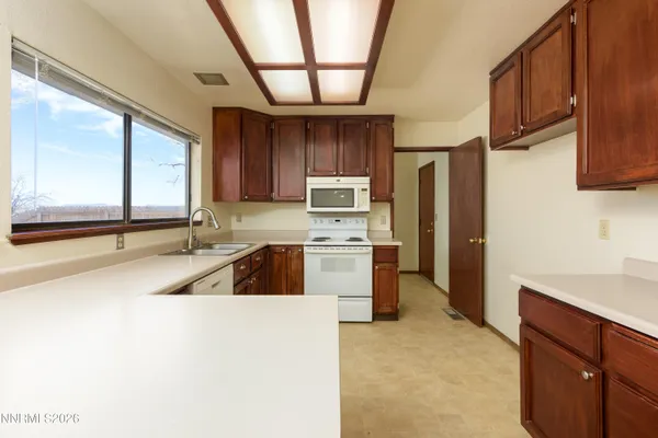 a kitchen with a sink cabinets stainless steel appliances and a window