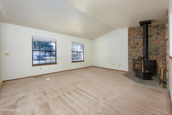 a view of an empty room with a fireplace and a window