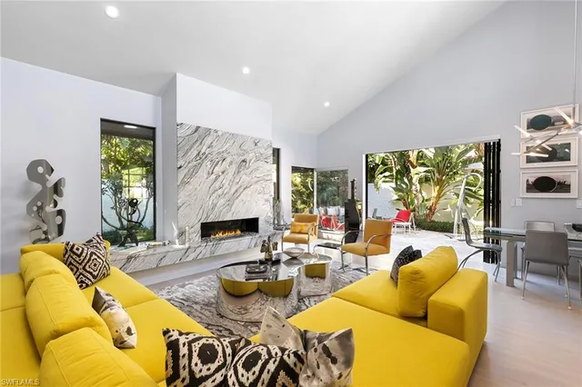 a living room with fireplace furniture and a large window