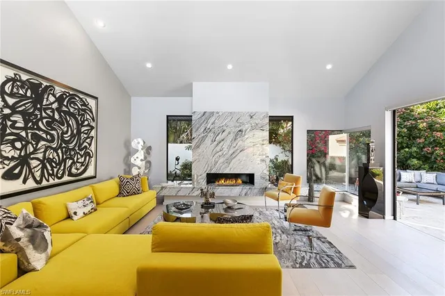 a living room with furniture fireplace and a large window