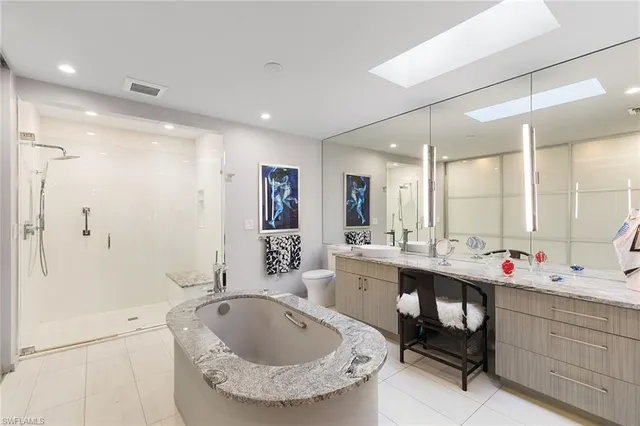a bathroom with a tub sink shower and mirror