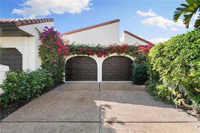 a front view of a house with a yard and potted plants