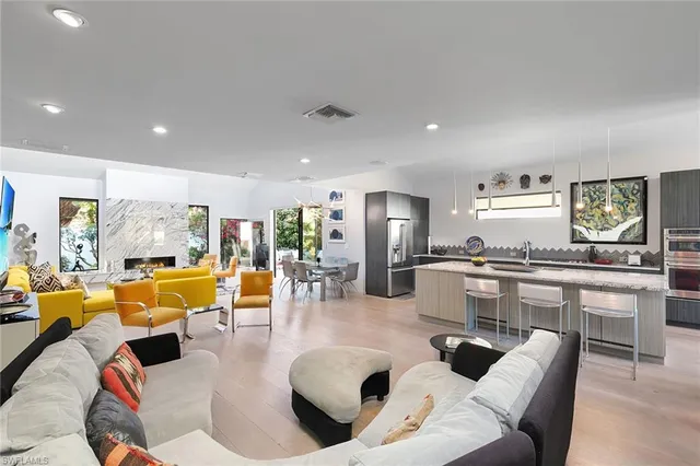 a living room with furniture kitchen view and a large window
