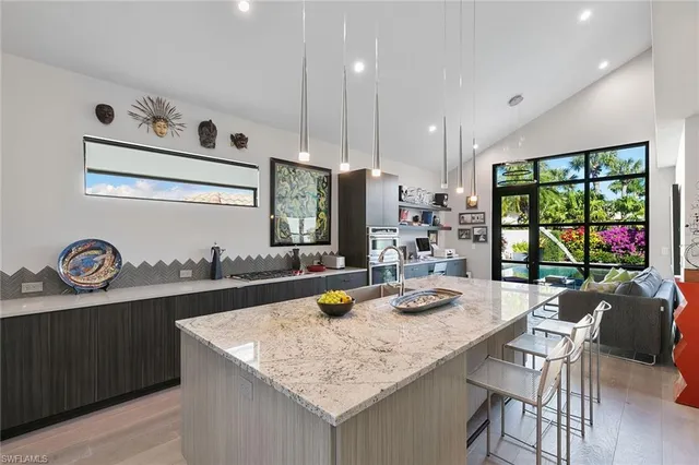 a kitchen with kitchen island granite countertop a sink and a stove