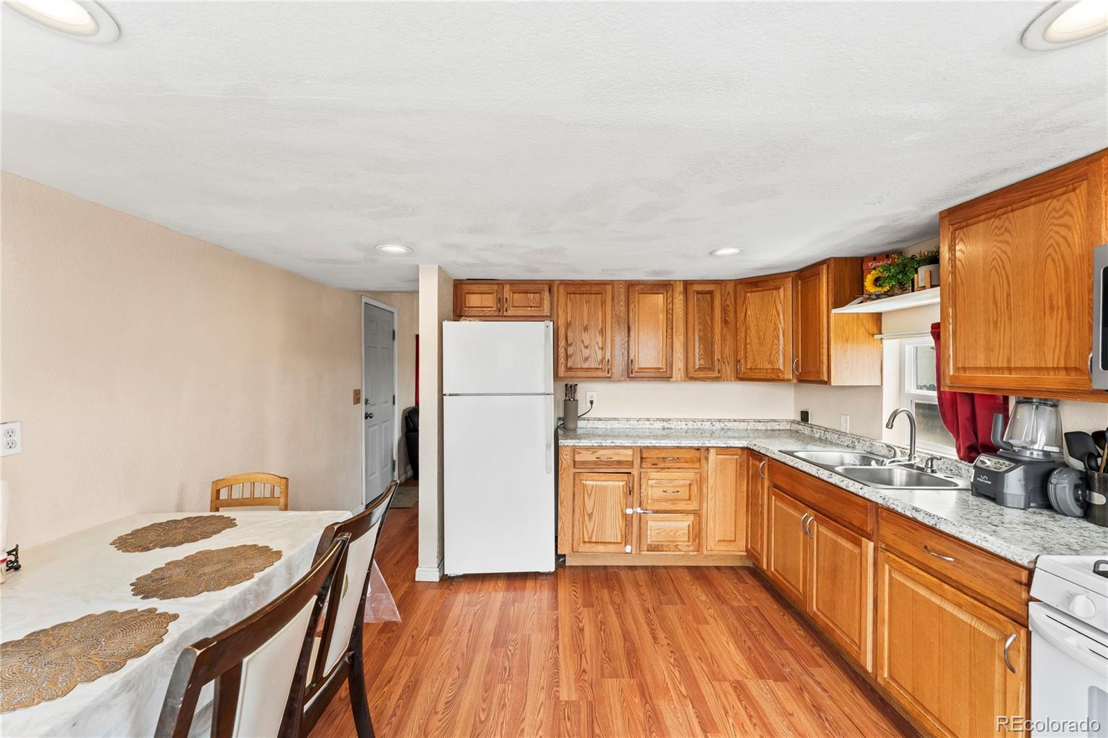75 North Curtis Road Colorado Springs, CO 80930 - Photo 9 of 19 a large kitchen with a wooden floor and cabinets