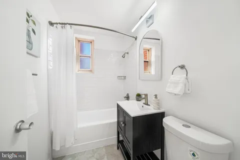 a bathroom with a toilet sink vanity and mirror