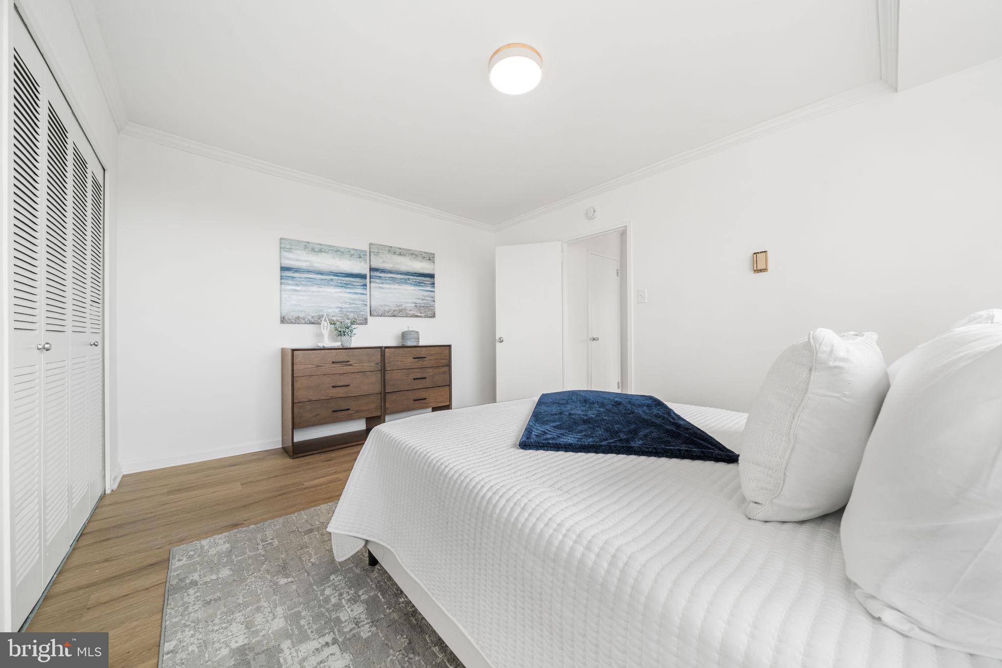4000 Tunlaw Road Northwest, Unit 811 Washington, DC 20007 - Photo 21 of 51 a bedroom with a bed and a painting on the wall