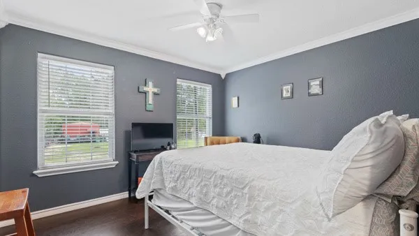a bedroom with a bed wooden floor and window