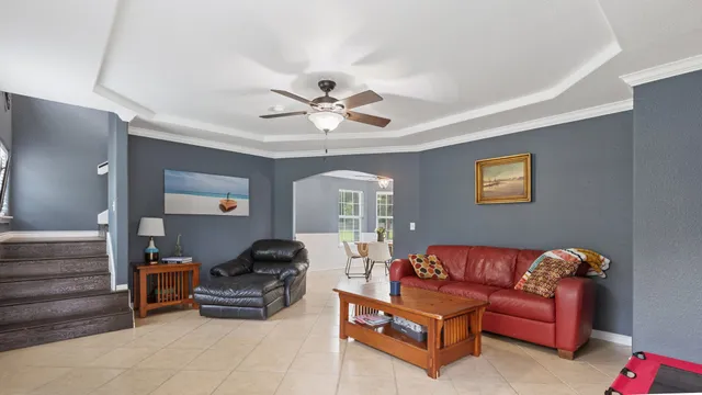 a living room with furniture a ceiling fan and a rug