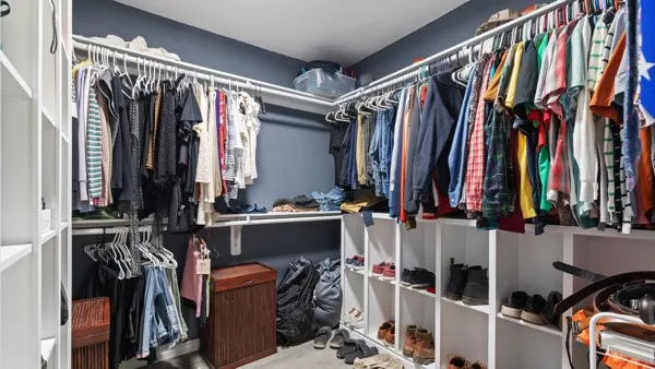 a view of walk in closet with clothes and shoes