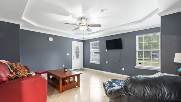 a living room with furniture a flat screen tv and a window