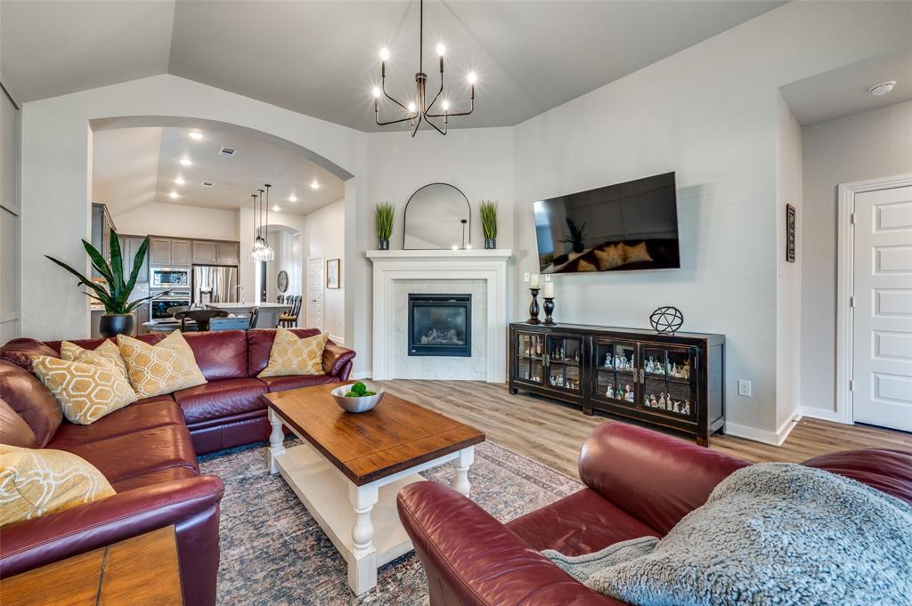 3513 Dusty Miller Road Aubrey, TX 76227 - Photo 2 of 25 a living room with furniture a fireplace and a flat screen tv