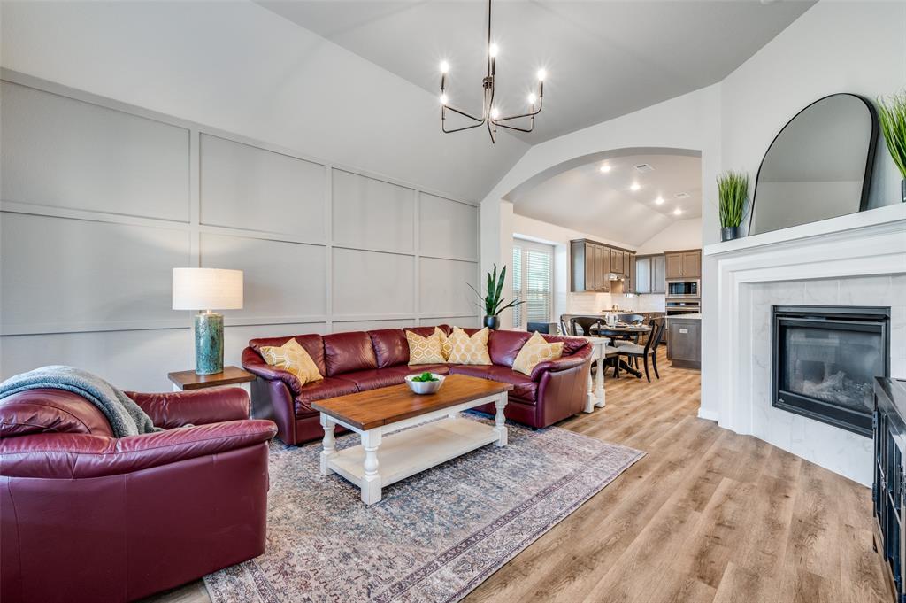 3513 Dusty Miller Road Aubrey, TX 76227 - Photo 3 of 25 a living room with furniture or chandelier and a fireplace