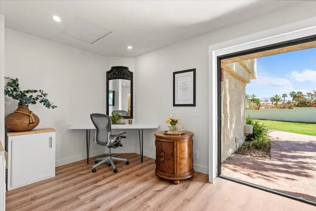 a view of a workspace with furniture and a window
