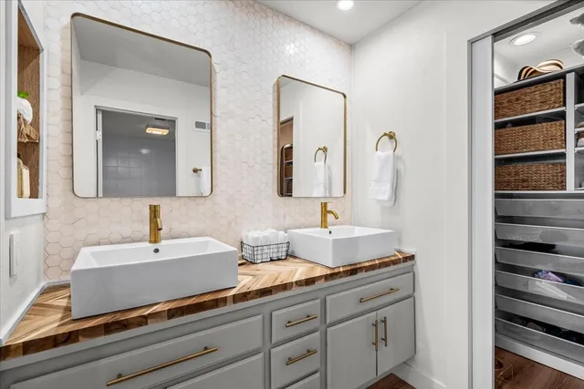 a bathroom with a double vanity sink and two mirror