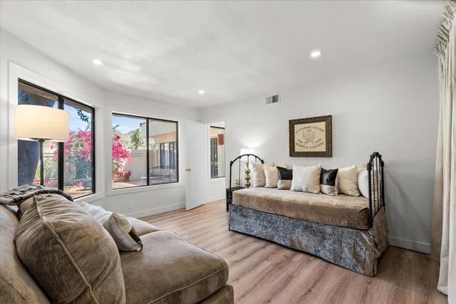 a living room with a bed furniture and a large window