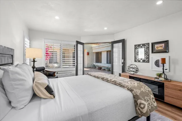 a bedroom with a bed and wooden floor