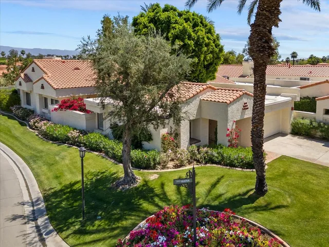 a front view of a house with a garden and yard