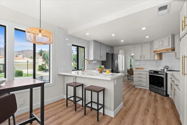 a kitchen with a table chairs stove and cabinets
