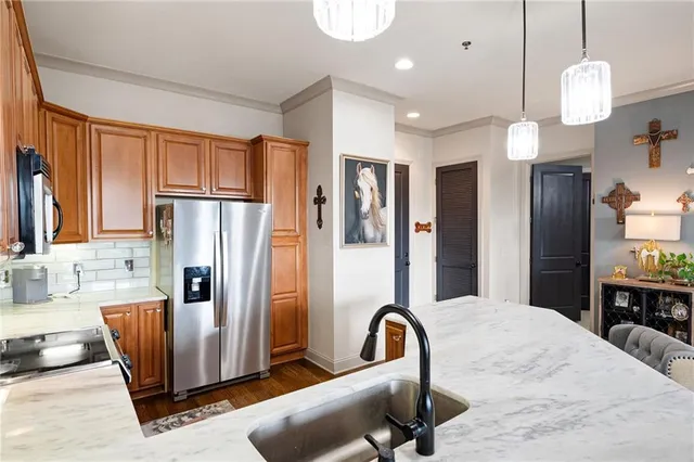a kitchen with stainless steel appliances granite countertop sink a refrigerator and a refrigerator