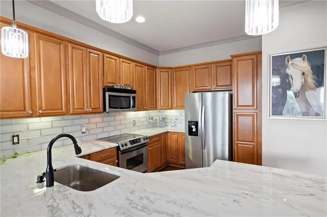 a kitchen with stainless steel appliances granite countertop a refrigerator a sink a stove a oven with white cabinets and wooden floor