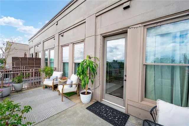 a view of a porch with chairs and potted plants