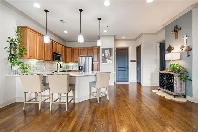 a kitchen with stainless steel appliances granite countertop wooden floor window and cabinets