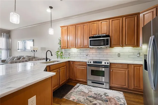 a kitchen with stainless steel appliances granite countertop a stove a sink and a microwave