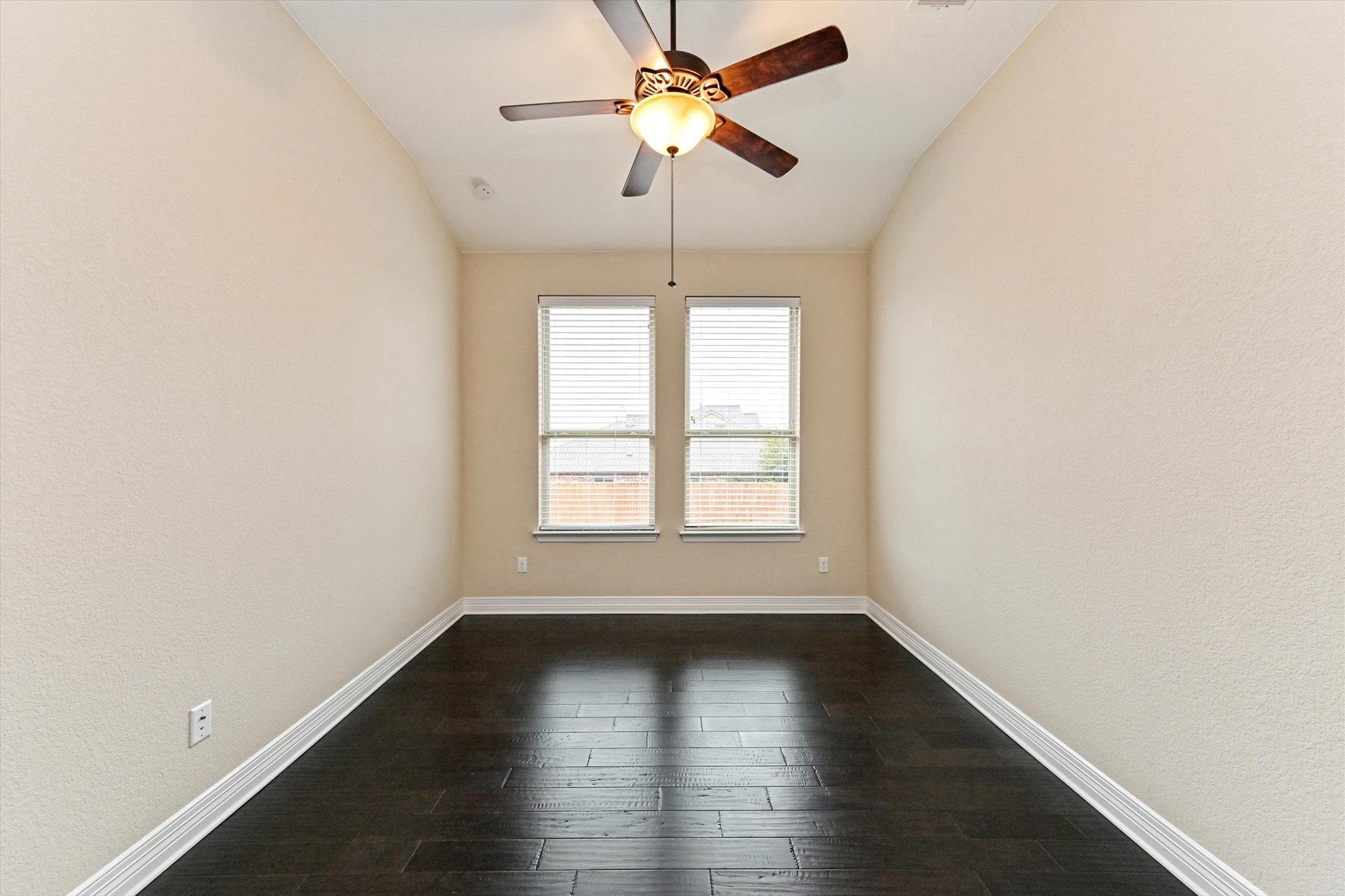 18500 Rio Chama Lane Austin, TX 78738 - Photo 12 of 28 This room features dark wood flooring, a vaulted ceiling, and two windows with blinds