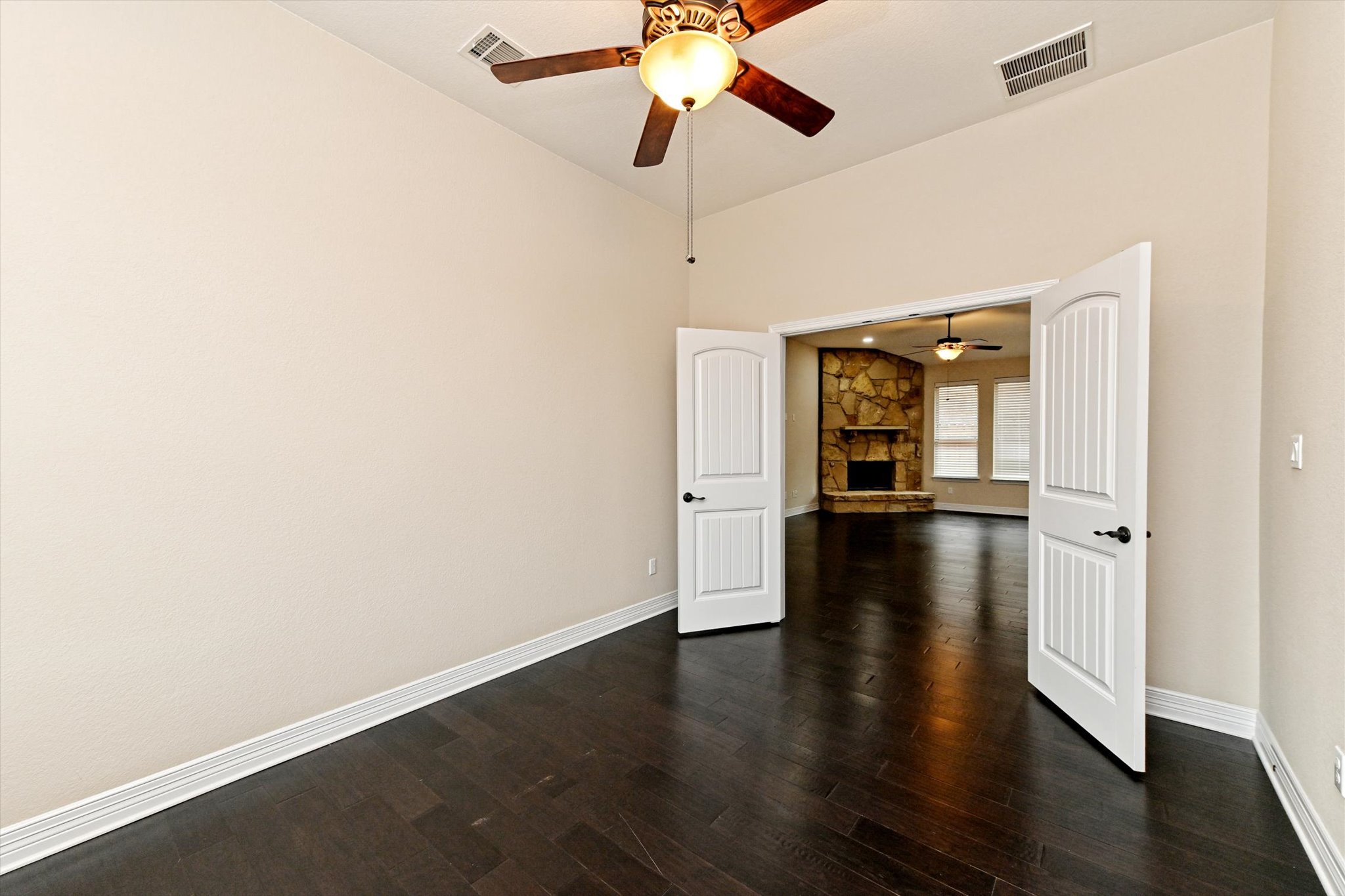 18500 Rio Chama Lane Austin, TX 78738 - Photo 13 of 28 This versatile room features dark hardwood flooring, a ceiling fan, and double doors opening to another living area