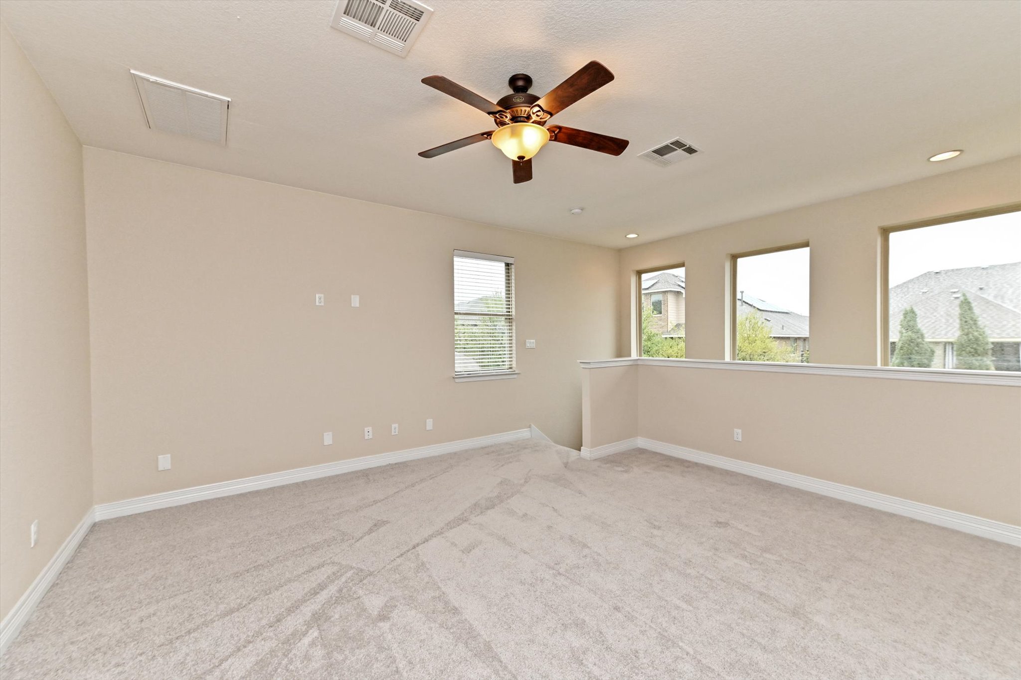 18500 Rio Chama Lane Austin, TX 78738 - Photo 14 of 28 Spacious room featuring light-colored carpet, a ceiling fan with integrated lighting, and multiple windows providing natural light