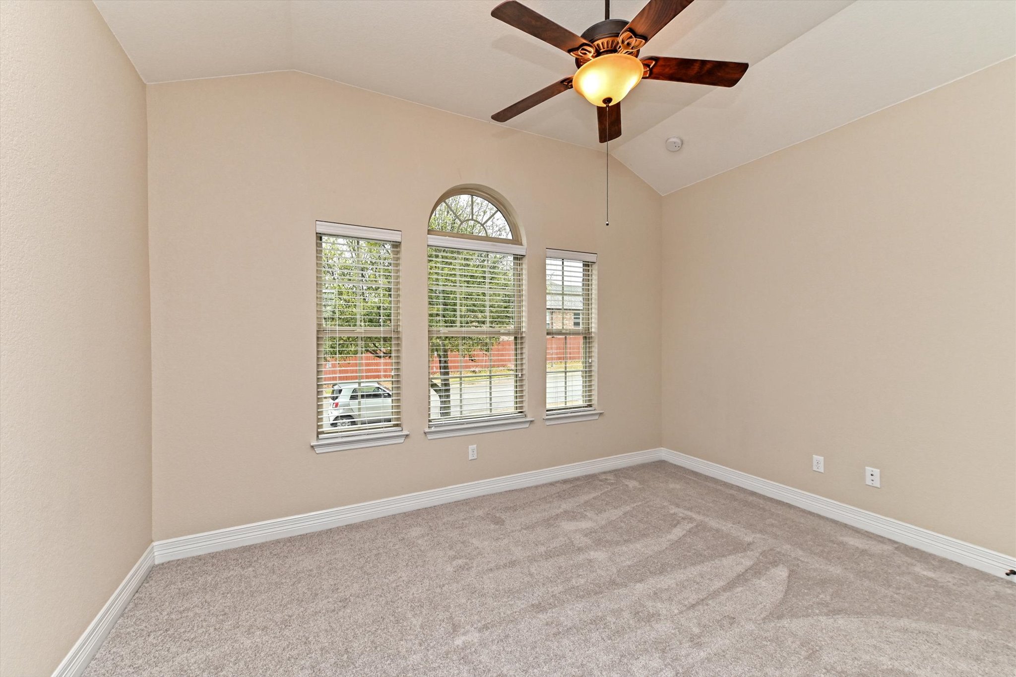 18500 Rio Chama Lane Austin, TX 78738 - Photo 22 of 28 This room features vaulted ceilings, a ceiling fan with light fixture, and three windows, one of which is an arched window