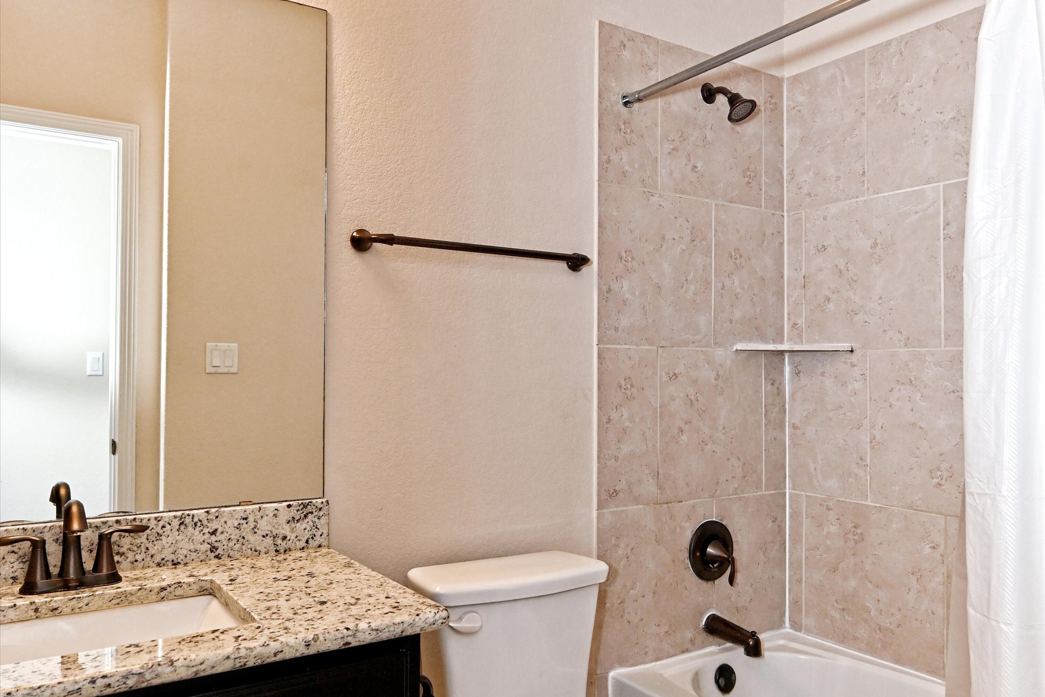18500 Rio Chama Lane Austin, TX 78738 - Photo 23 of 28 Bathroom featuring a vanity with a granite countertop and a sink with a bronze faucet