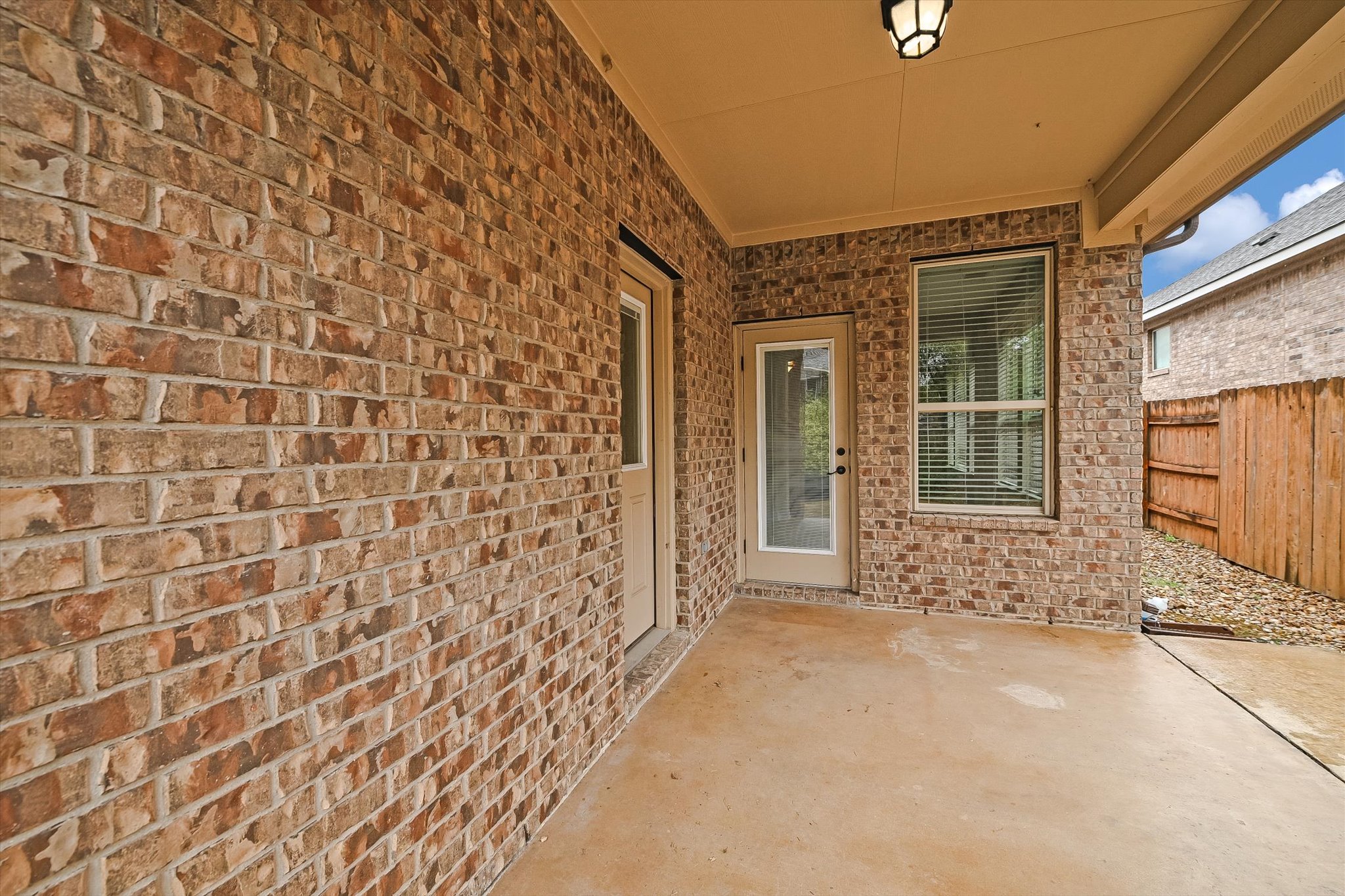18500 Rio Chama Lane Austin, TX 78738 - Photo 26 of 28 Covered patio featuring a concrete floor, brick exterior walls, and a recessed light fixture