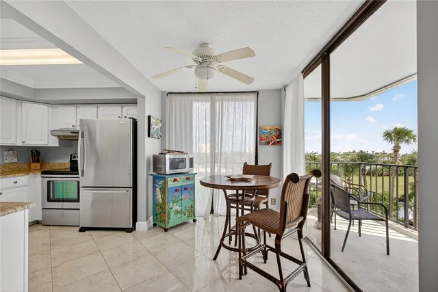 a kitchen with a refrigerator a dining table and chairs
