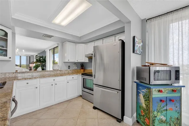 a kitchen with stainless steel appliances granite countertop a refrigerator and a sink