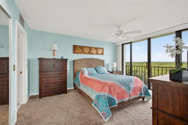 a bedroom with a bed and large windows