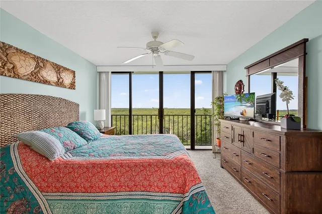 a living room with furniture large windows and a flat screen tv