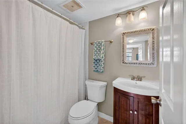 a bathroom with a sink a toilet and shower curtain