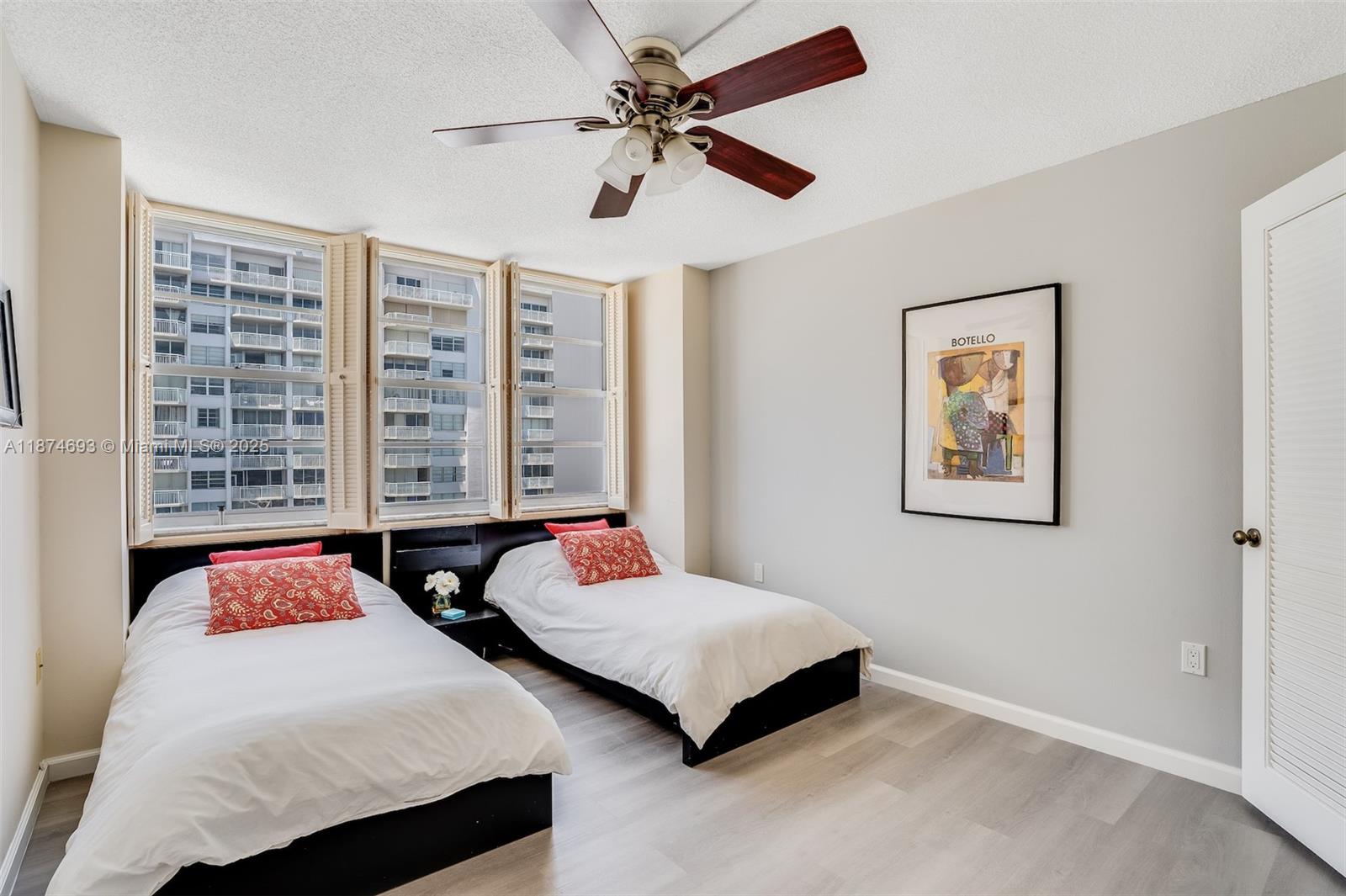 18041 Biscayne Boulevard, Unit 1404 Aventura, FL 33160 - Photo 13 of 22 a bedroom with a bed a window and a chandelier